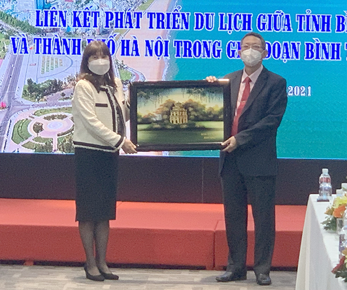Bà Đặng Hương Giang, Giám đốc Sở Du lịch Hà Nội tặng quà lưu niệm cho ông Trần Văn Thanh, Giám đốc Sở Du lịch tỉnh Bình Định